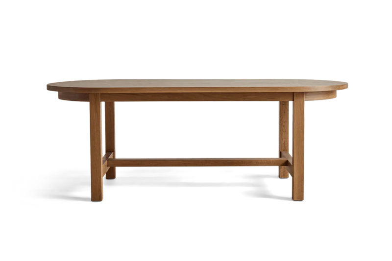 Close-up of a wooden table with a rounded edge, showing the grain and finish of the wood.