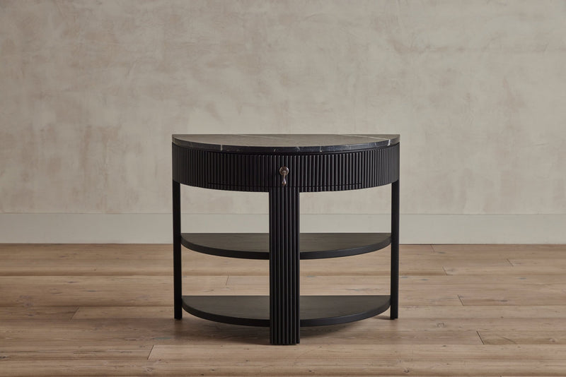 A semi-circular wooden side table with a black marble top, grooved detailing, and a lock, shown from the front.