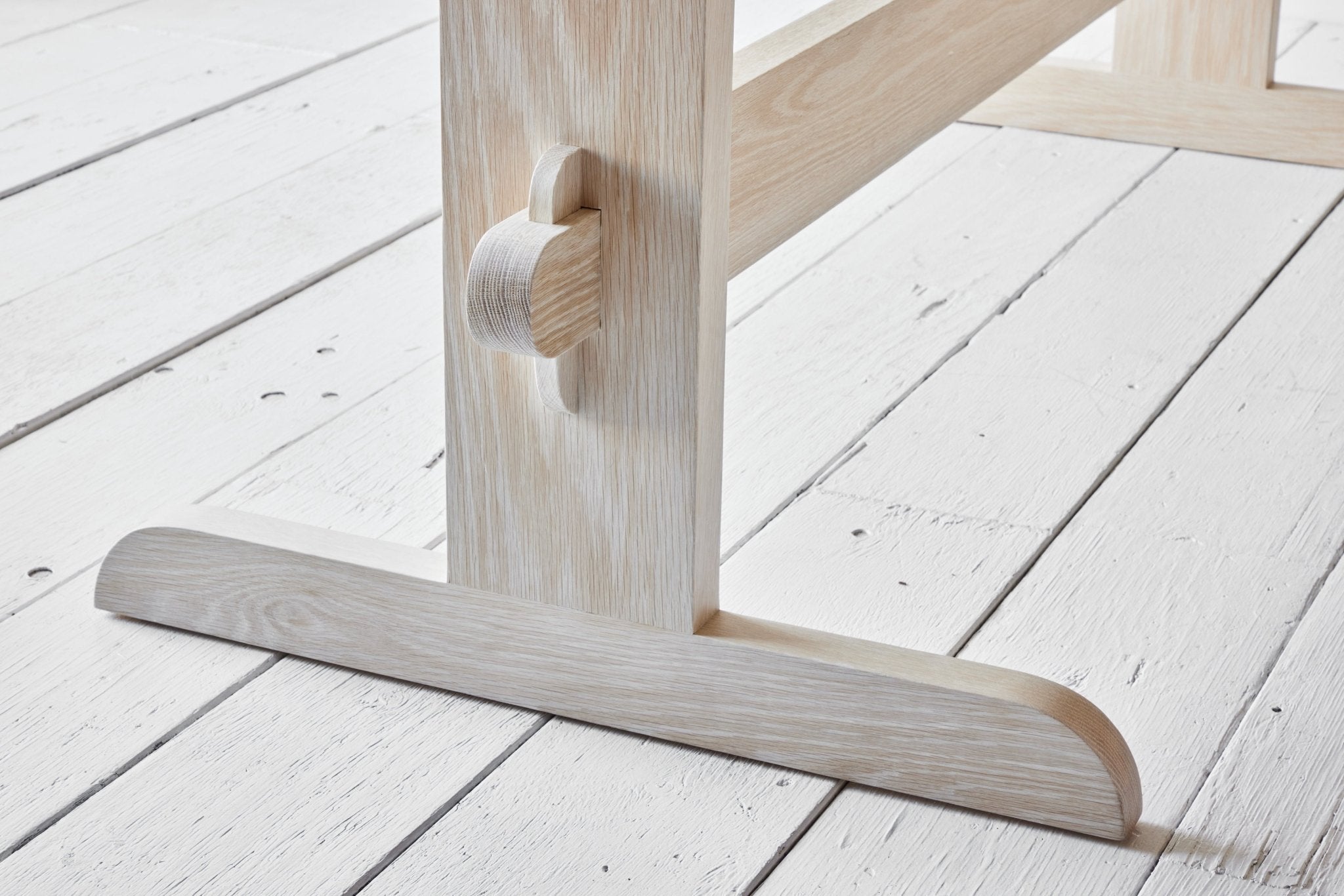 Close-up of the leg joint and wood grain of the dining table.
